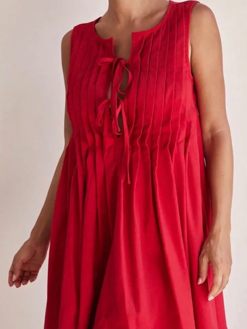 Red sleeveless jumpsuit featuring a relaxed, wide-leg